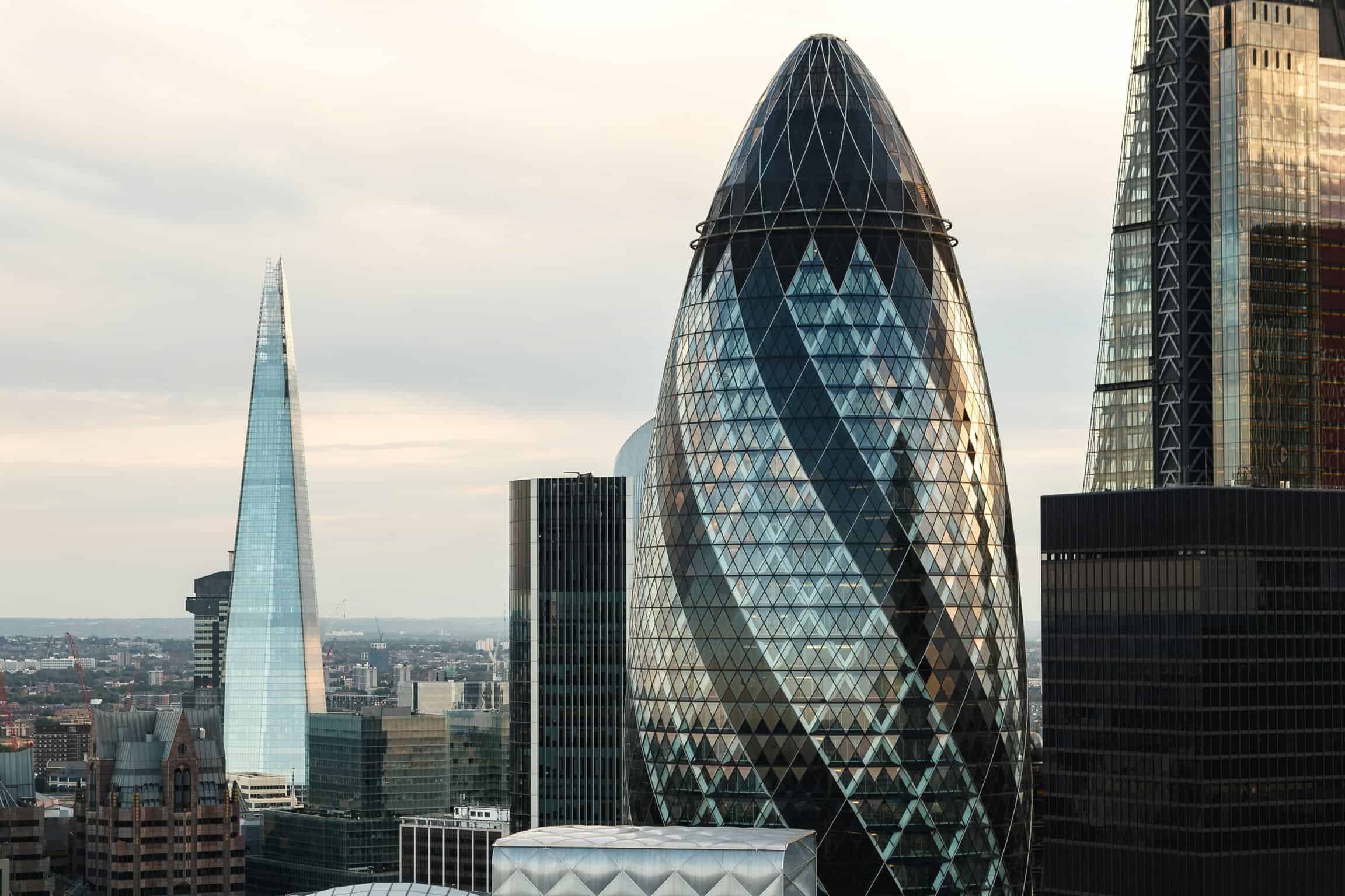 Modern London skyline featuring The Gherkin and other skyscrapers, showcasing iconic architecture and urban development.