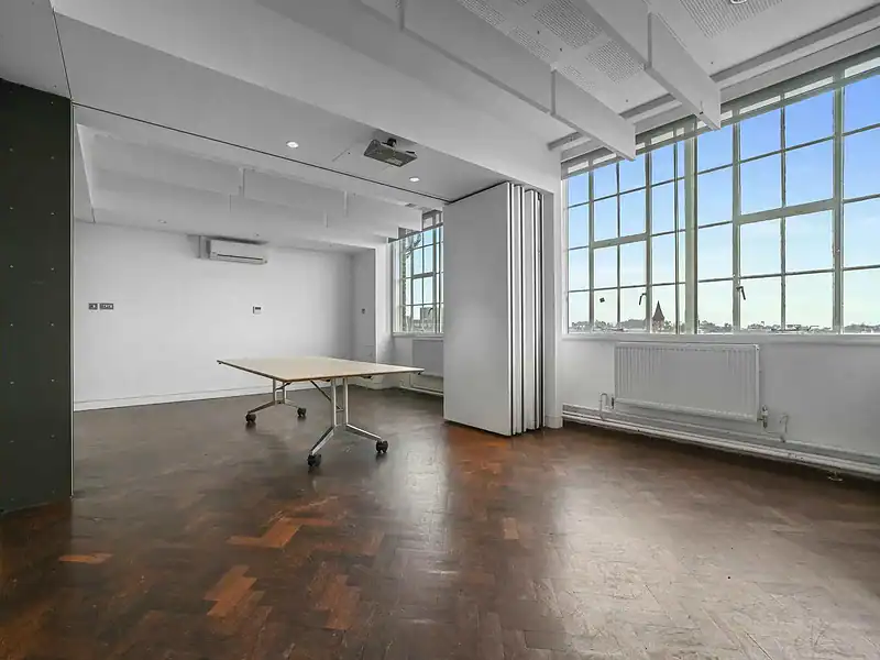 Spacious and bright office room in Islington with large windows, wooden flooring, and contemporary design, ideal for professional work environments.