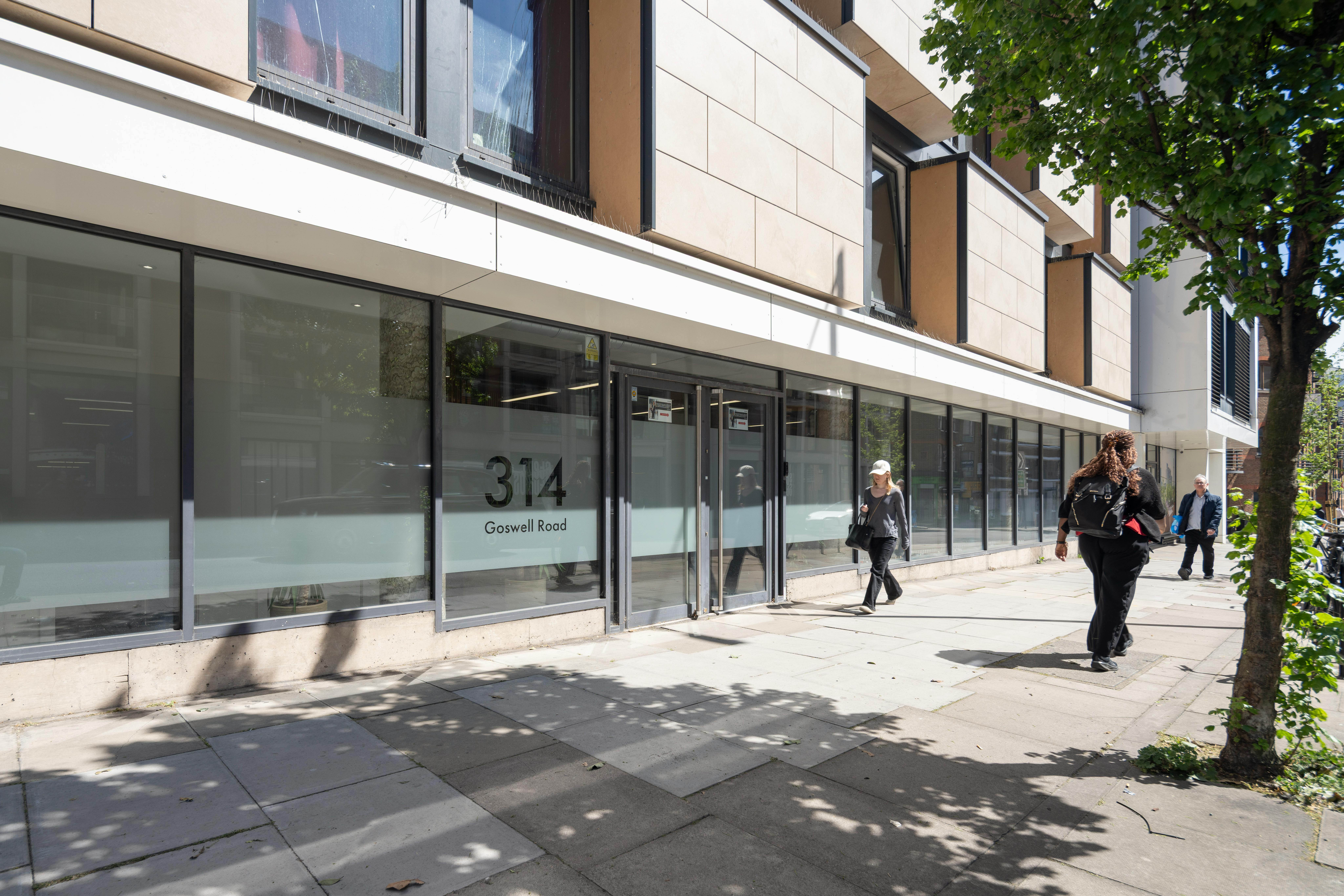 Bright, contemporary storefront with large glass windows and street view, showcasing urban architecture and pedestrian activity.