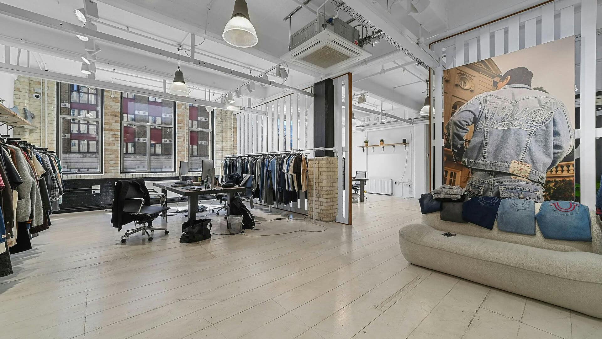 Bright and spacious retail space showcasing casual and designer apparel with large windows, stylish decor, and organized clothing displays for an optimal shopping experience.
