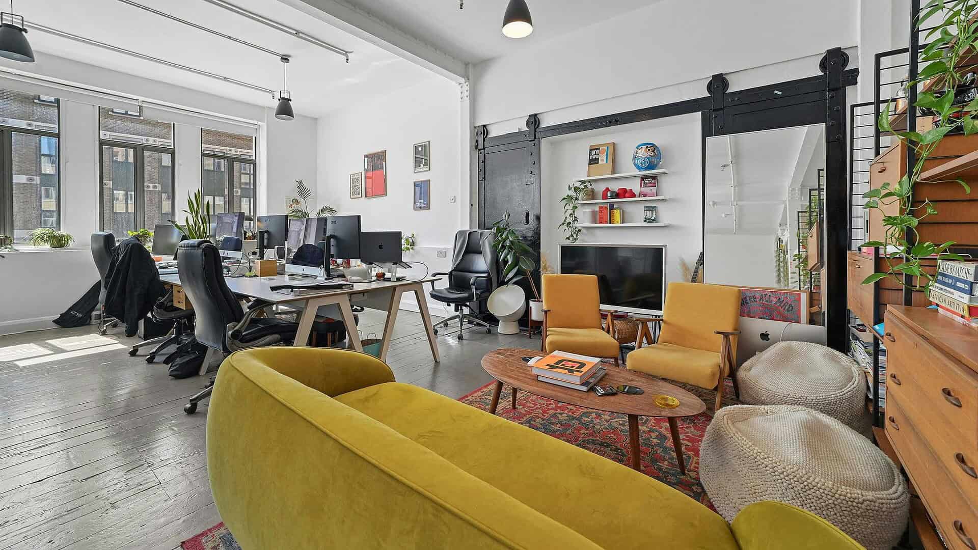 Bright and spacious coworking environment featuring desks, comfortable seating, and contemporary decor in a stylish London office setting.