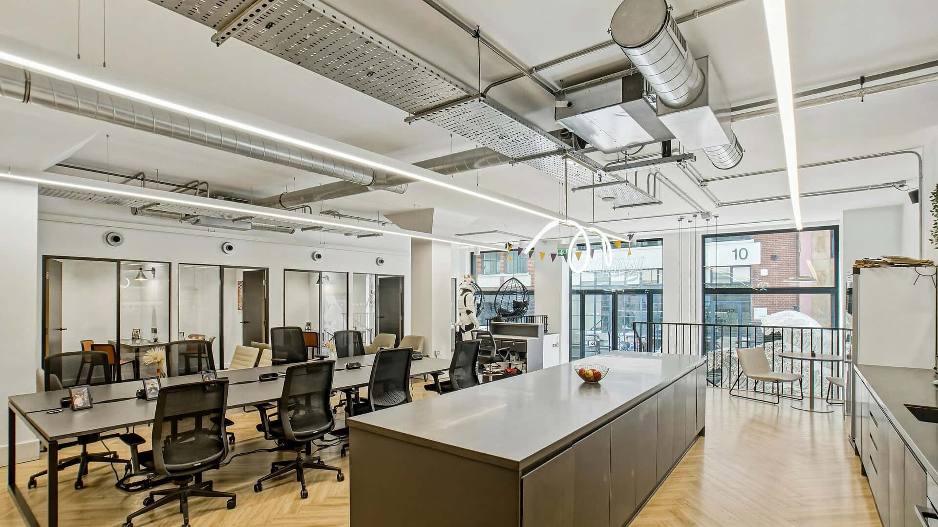 Spacious and modern office interior with workstations, chairs, and large windows at 14 Bonhill Street, EC2A 4BX, London, showcasing contemporary workspace design.