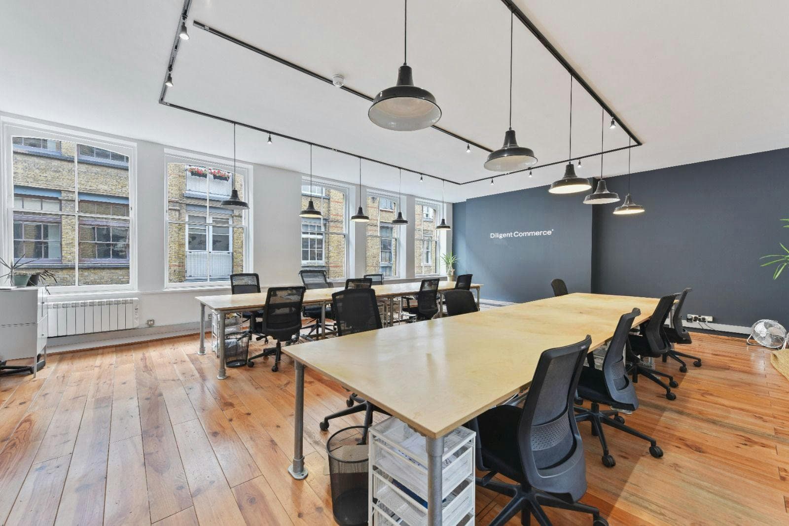 Spacious modern office conference room with large windows, wooden flooring, and ergonomic chairs, ideal for meetings and collaborative work at Belcor London.