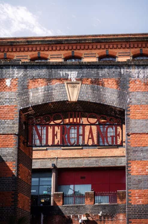 Historic brick building with a sign reading 'The Interchange' in red letters, located in NW1 7DZ, London, showcasing classic industrial architecture.