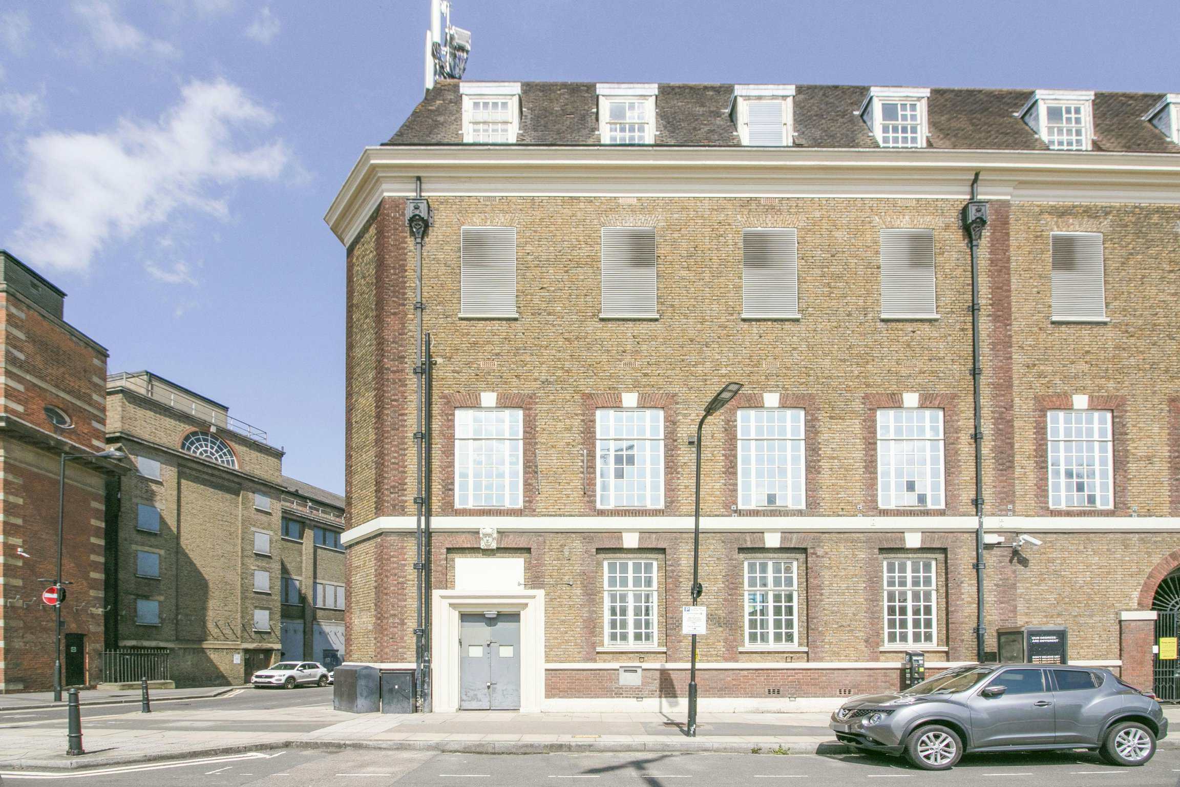 Traditional brick building exterior in London, featuring large windows and a classic architectural style.