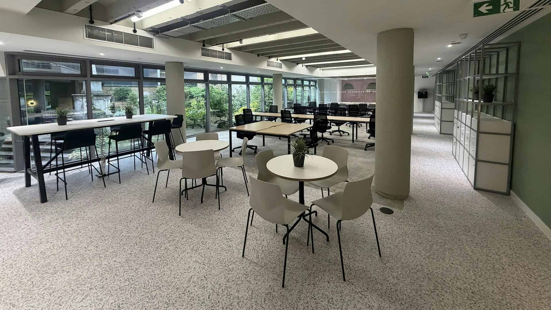 Bright, modern office interior with large windows, round tables, and comfortable chairs, located at 39 Tabernacle Street EC2A 4AA, London.